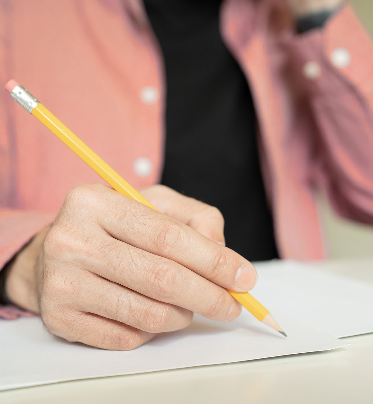 Eine Person hält einen Stift in der Hand und schreibt
